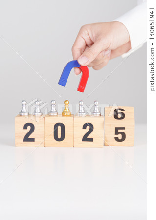 hand holding magnet and pulling man chess figure from the crowd employee with 2026 Year block. Human resource management, Recruitment, Teamwork, strategy, toxic people and leadership Concepts 130651941