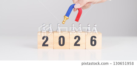 hand holding magnet and pulling man chess figure from the crowd employee with 2026 Year block. Human resource management, Recruitment, Teamwork, strategy, toxic people and leadership Concepts 130651958