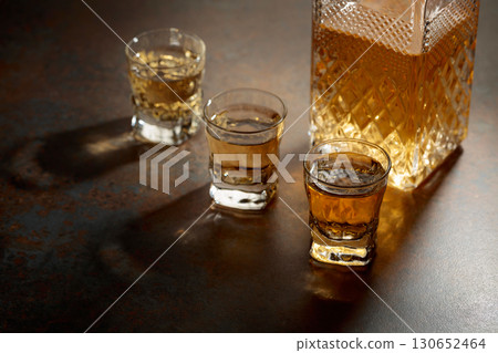 Decanter and small glasses of whiskey. 130652464