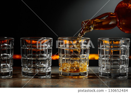 Whiskey is poured into a crystal glass. 130652484
