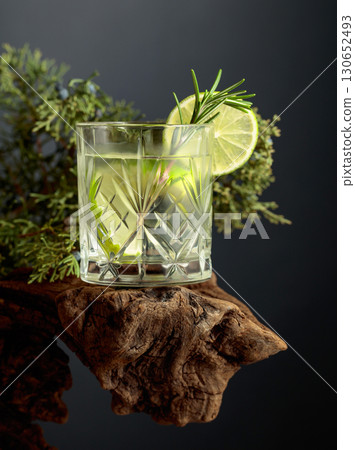 Refreshing hard seltzer with ice, lime, and rosemary on an old snag. Refreshing hard seltzer with ice, lime, and rosemary on an old snag. 130652493