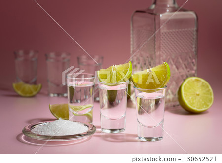 Mexican tequila with lime and sea salt on a pink background. Mexican tequila with lime and sea salt on a pink background. 130652521