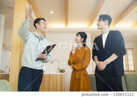 A man in work clothes showing around a model room 130653122
