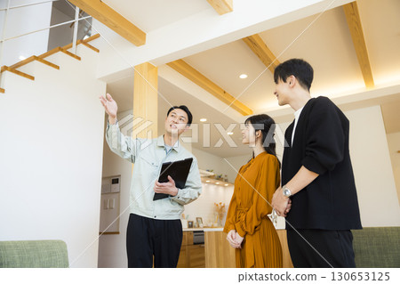 A man in work clothes showing around a model room 130653125