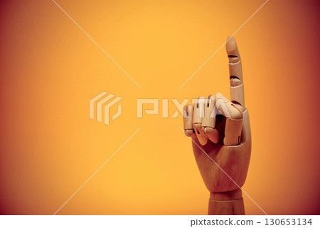 Wooden finger pointing upwards close-up Wooden finger pointing upwards close-up 130653134