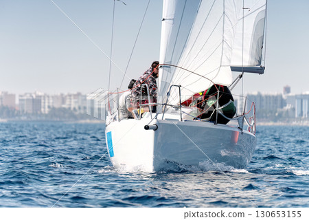 Sailboat and crew racing towards the finish line in a regatta 130653155