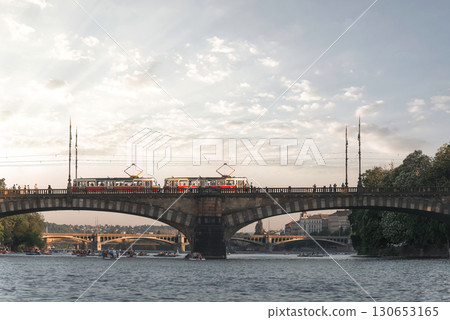 Trams crossing a bridge over the Vltava river in Prague while rowers enjoy the water. Czech Republic Trams crossing a bridge over the Vltava river in Prague while rowers enjoy the water. Czech Republic 130653165