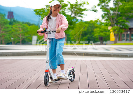 Asian girl is going to ride a scooter. Copy space 130653417