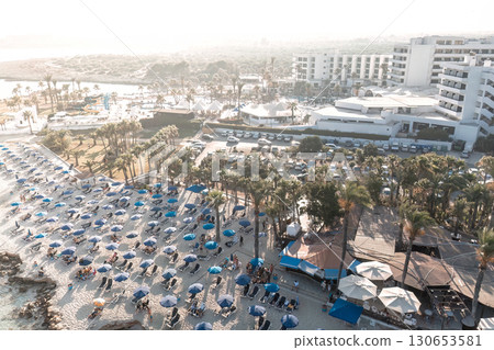Tourists relaxing on Nissi beach with hotels and resorts in background. Ayia Napa, Cyprus 130653581
