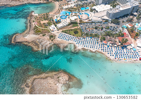 Turquoise water surrounding beachgoers relaxing on the coast of cyprus 130653582