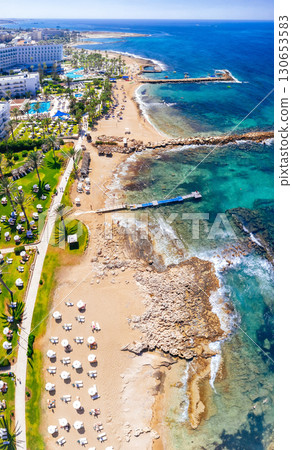 Aerial view of tourists relaxing on beautiful sandy beach with turquoise water. Geroskipou, Paphos District, Cyprus 130653583