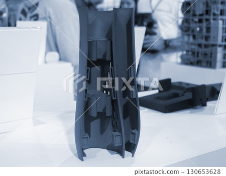 Object printed on 3D printer from molten plastic powder close-up. Model of black color printed on 3D printer from melted polyamide powder. Modern additive 3D printing technology. Multi Jet Fusion MJF Object printed on 3D printer from molten plastic powder close-up. Model of black color printed on 3D printer from melted polyamide powder. Modern additive 3D printing technology. Multi Jet Fusion MJF 130653628