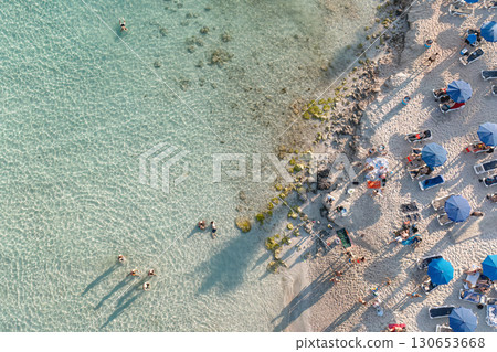 Aerial view of tourists enjoying summer vacation relaxing on beach and swimming in the sea. Cyprus Aerial view of tourists enjoying summer vacation relaxing on beach and swimming in the sea. Cyprus 130653668