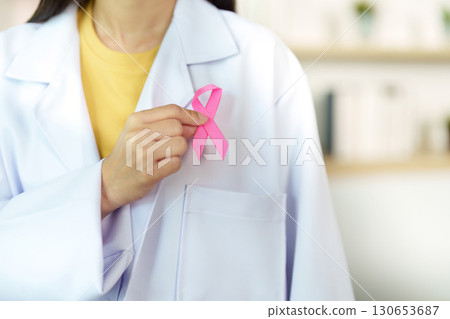 Breast Cancer Awareness. Medical professional displaying pink ribbon symbol. Breast Cancer Awareness. Medical professional displaying pink ribbon symbol. 130653687