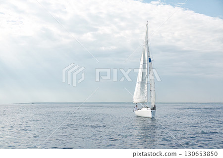 Sailboat sailing in the sea with sails up on a cloudy day Sailboat sailing in the sea with sails up on a cloudy day 130653850