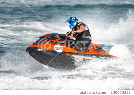 Pilot is riding a jet ski during a competition on the sea Pilot is riding a jet ski during a competition on the sea 130653851