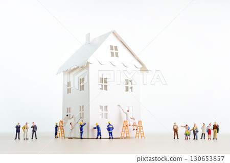 Miniature workers painting a white paper house with customers watching Miniature workers painting a white paper house with customers watching 130653857