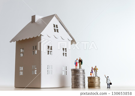 Miniature people standing on stacks of coins with miniature house and real estate agent Miniature people standing on stacks of coins with miniature house and real estate agent 130653858