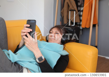 an adult woman listening music at her home in headphones, lifestyle people an adult woman listening music at her home in headphones, lifestyle people 130653901