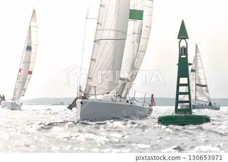 Sailboat passing green buoy during regatta with other boats competing Sailboat passing green buoy during regatta with other boats competing 130653971