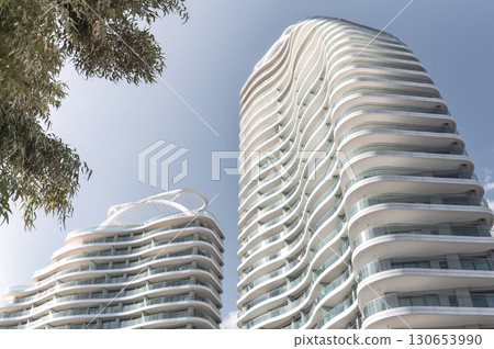 Modern high rise apartment building exterior with wavy balconies reaching up to the sky. Limassol, Cyprus Modern high rise apartment building exterior with wavy balconies reaching up to the sky. Limassol, Cyprus 130653990