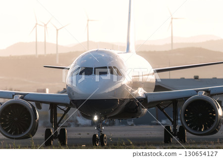 Passenger airplane at airport runway with wind turbines in background. Larnaca, Cyprus 130654127