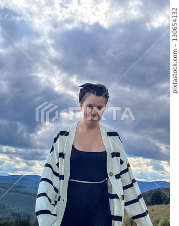 Woman Enjoying Mountain View on Grassy Hill 130654132