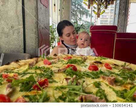 Mother and Baby Enjoying Pizza at a Restaurant Mother and Baby Enjoying Pizza at a Restaurant 130654141