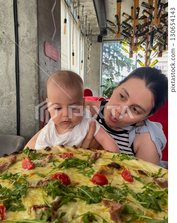Mother and Baby Enjoying Pizza at a Restaurant Mother and Baby Enjoying Pizza at a Restaurant 130654143