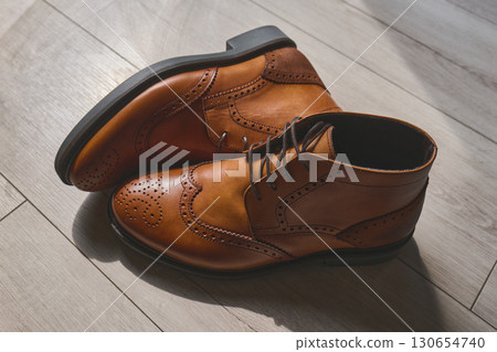 Elegant brown dress shoes on wooden floor 130654740