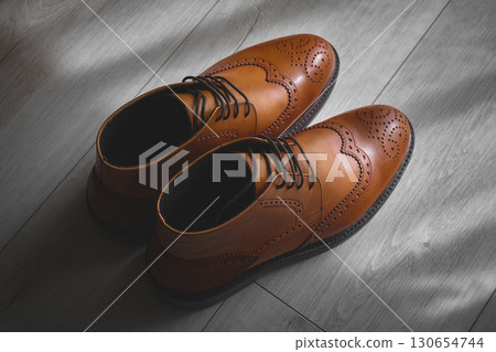 Elegant brown dress shoes on wooden floor Elegant brown dress shoes on wooden floor 130654744