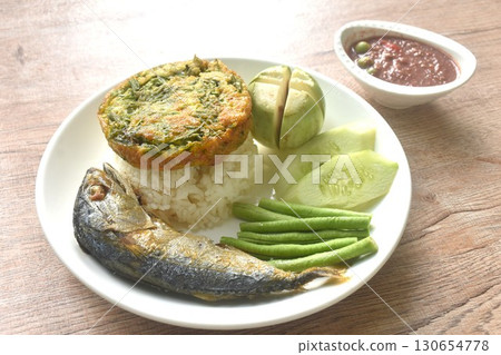 batter fried egg stuffed acacia and mackerel with fresh vegetable on rice in plate dipping spicy shrimp paste sauce 130654778