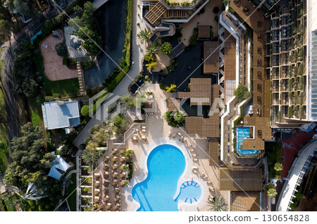 Aerial view of a luxury hotel complex with swimming pool, gardens, and sun loungers in Limassol, Cyprus Aerial view of a luxury hotel complex with swimming pool, gardens, and sun loungers in Limassol, Cyprus 130654828