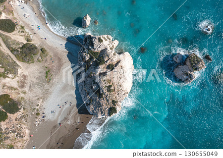 Tourists relaxing on beach by Petra tou Romiou (Aphrodite's rock) in Cyprus. Paphos District 130655049