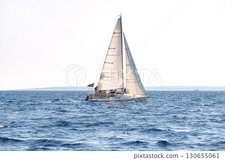 Graceful yacht sails in the glistening mediterranean sea during a competitive regatta 130655061