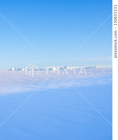 北海道美瑛的冬日雪景，藍天白雲和十勝山脈的景色 130655331