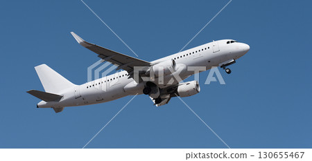 Airplane take off on the blue sky, Aircraft flying on sky background. White passenger jet plane in the blue sky. Low angle view of Airplane flying under blue sky 130655467