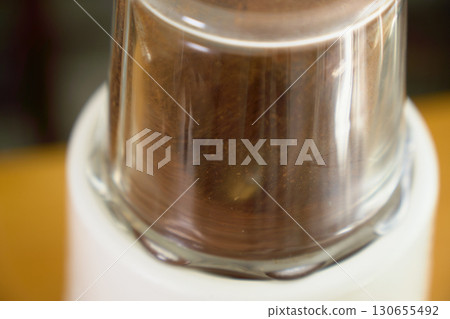 用電動研磨機磨咖啡豆。一系列照片展示了使用紙質滴濾咖啡機沖泡咖啡的過程。 用電動研磨機磨咖啡豆。一系列照片展示了使用紙質滴濾咖啡機沖泡咖啡的過程。 130655492