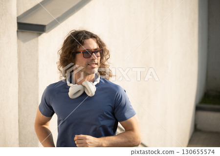 Sporty man and athlete wearing blue t-shirt running and jogging at stair. Urban style. Outdoor workout. Sporty man and athlete wearing blue t-shirt running and jogging at stair. Urban style. Outdoor workout. 130655574