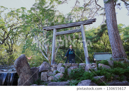 一位身著和服的女子在鳥居門前擺姿勢 | 日本花園,日式風格,旅遊形象 一位身著和服的女子在鳥居門前擺姿勢 | 日本花園,日式風格,旅遊形象 130655617