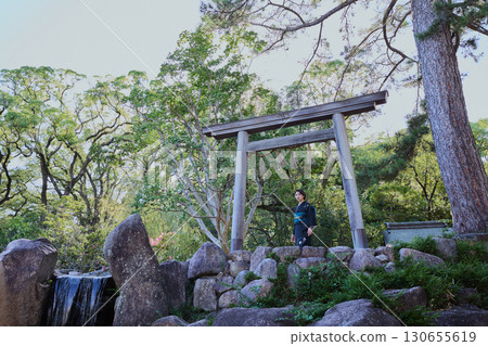 A woman in a kimono posing in front of a torii gate | Japanese garden, Japanese style, tourism image 130655619