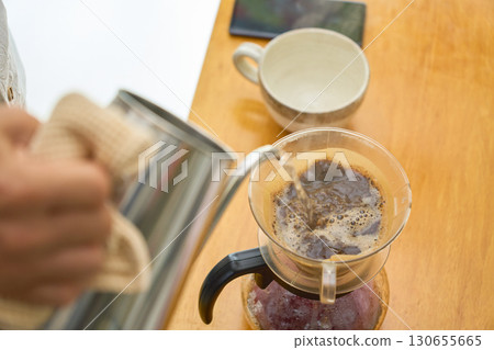 一位男士正在倒熱水，準備進行第二杯和第三杯沖泡。一系列照片展示了使用紙質濾杯沖泡咖啡的過程。 130655665