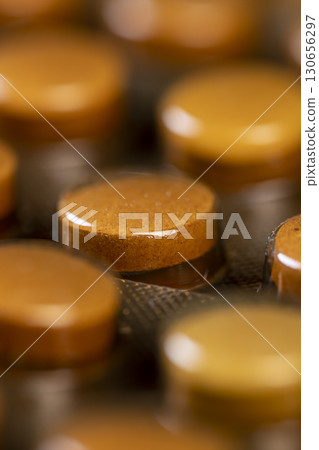 tablets in a blister, whole orange tablets packed in a metal-plastic blister closeup 130656297