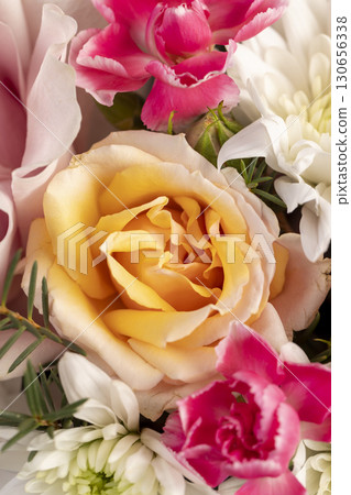 a gift arrangement of a large variety of flowers of different colors, a flower arrangement for giving from different colors and different types of flowers 130656338