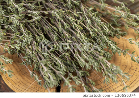 green thyme bound together for use in cooking and folk medicine, thyme spices lying on a wooden table during drying green thyme bound together for use in cooking and folk medicine, thyme spices lying on a wooden table during drying 130656374