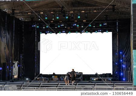 Stage crew setting up concert production with massive LED screen 130656449