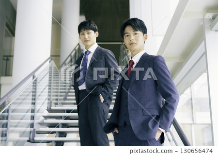 一位年輕商人站在辦公大樓樓梯上的肖像 130656474