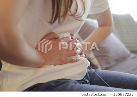 一名婦女因腹痛摀住肚子的圖片 130657222