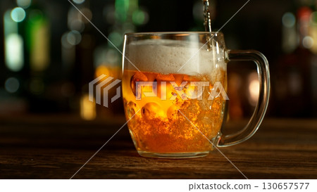 Pouring Beer into Pint Glass in a Pub, Close-up Pouring Beer into Pint Glass in a Pub, Close-up 130657577