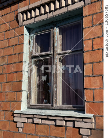 Window in a brick house. Dilapidated window frame. 130657595